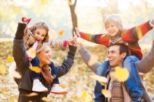 Kinder auf den Schulter ihrer Eltern im Herbst in der Natur