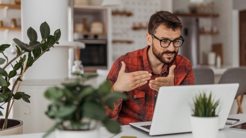 Mann sitzt vorm Laptop in einem Bewerbungsgespräch