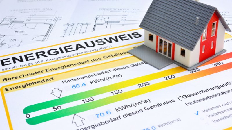 Energieausweis auf dem eine kleines Modellhaus steht.