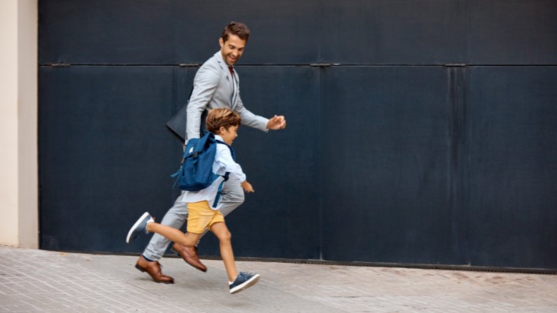 Berufstätiger Vater bringt seinen Sohn zur Schule.