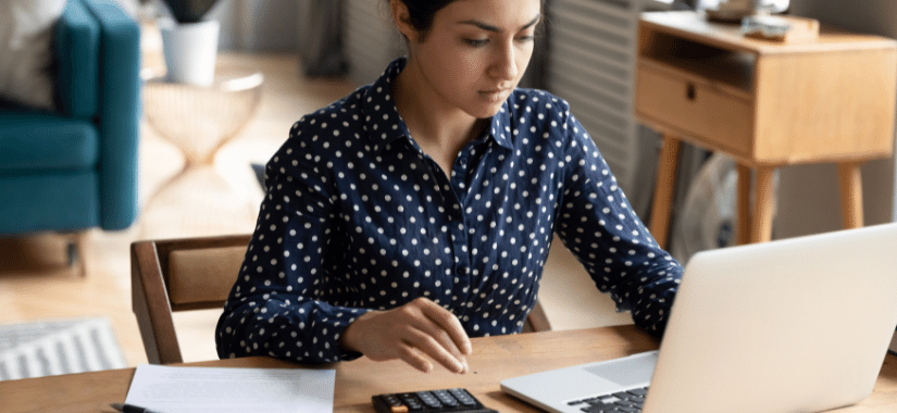 Frau vor Laptop und Taschenrechner