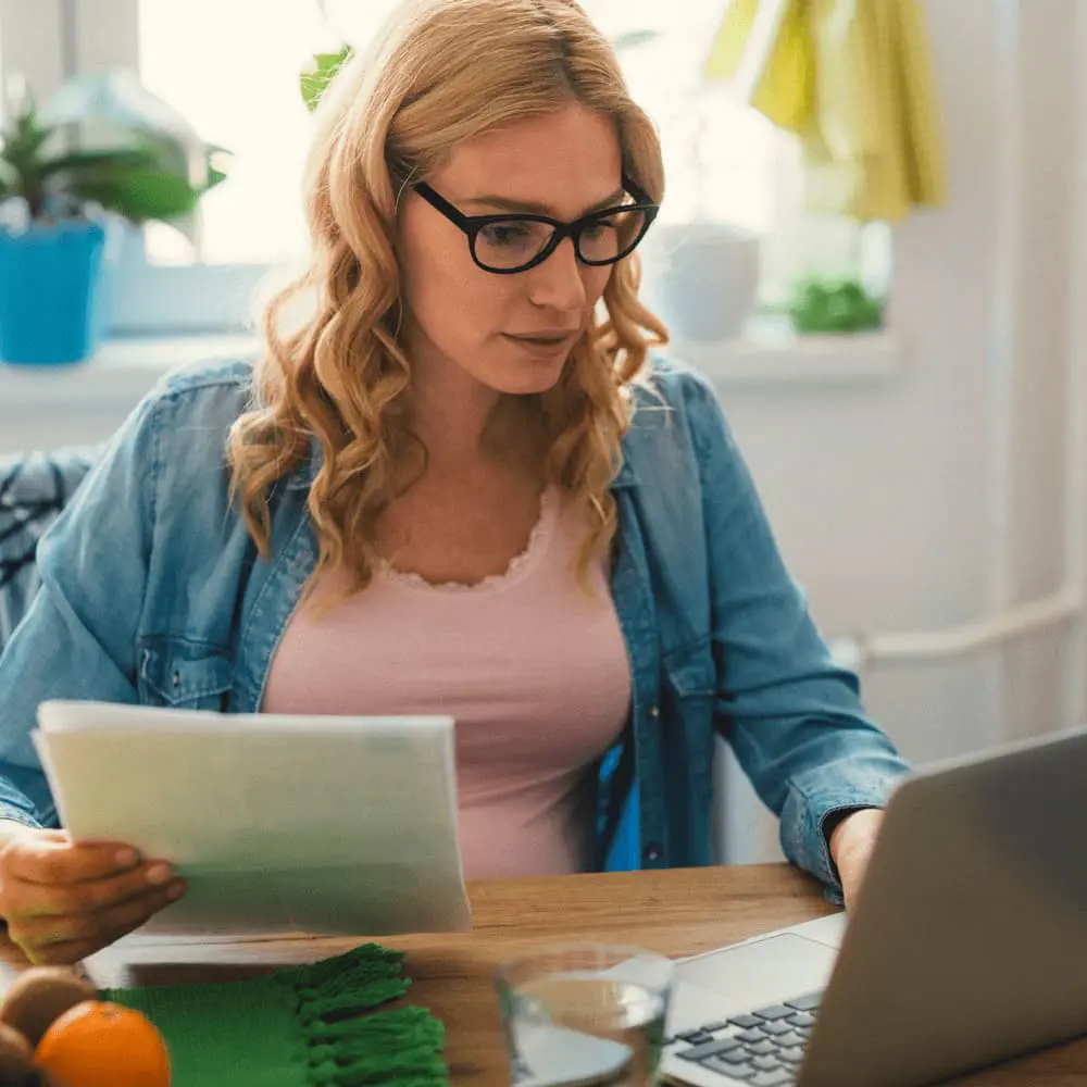 Junge Frau mit Brille arbeitet am Laptop