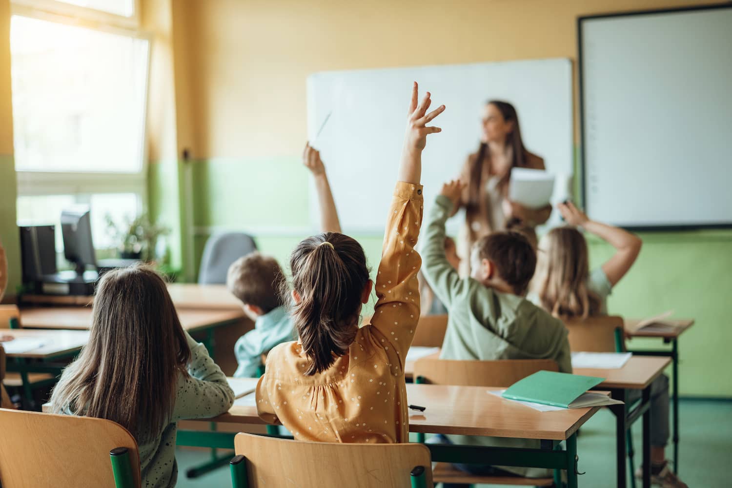 Grundschüler melden sich im Unterricht