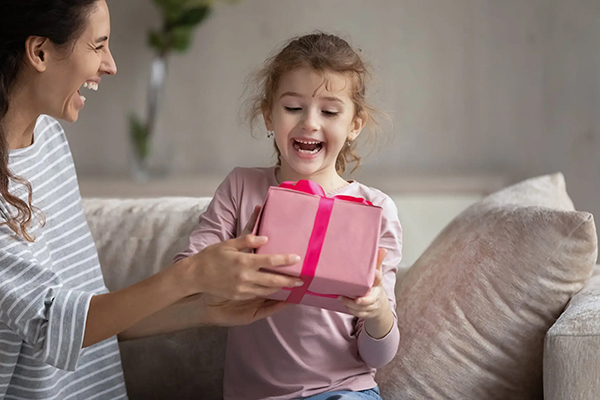 Mädchen freut sich über Geschenk von Mutter